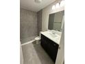Modern bathroom with grey tiled walls, sleek vanity and marble countertop and walk in shower at 2350 Sw 150Th Ct, Ocala, FL 34481