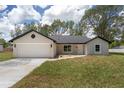 Attractive single-story home featuring a two-car garage and manicured front lawn at 26 Water Track Dr, Ocala, FL 34472