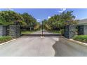 A black iron gate with stone pillars and gold accents guards the entrance to the private community at 2908 Se 22Nd Ave, Ocala, FL 34471