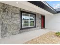 Close-up of front entrance with stone, decorative landscaping, and covered doorway at 36 Pine Radl, Ocala, FL 34472
