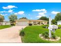 Charming home with a manicured lawn, mature landscaping, and a driveway leading to a two-car garage at 6172 Sw 101St Pl, Ocala, FL 34476