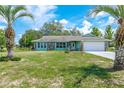 Charming home featuring stone accents, well-manicured lawn, and an attached garage at 6773 Se 87Th St, Ocala, FL 34472