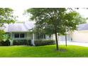 View of the exterior showing the well-manicured landscaping surrounding the charming one-story home with an attached garage at 8655 Sw 98Th Street Rd # G, Ocala, FL 34481