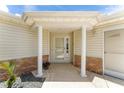 Welcoming front entrance with white columns, brick accents, and a storm-protected front door at 8689 Se 141St Street Rd, Summerfield, FL 34491
