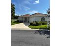 Charming single story home with well-manicured landscaping, a two-car garage, and a concrete driveway at 8689 Se 141St Street Rd, Summerfield, FL 34491