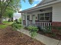 Welcoming front porch with white railing and brick accents, complemented by neatly trimmed shrubs at 8959 Sw 96Th Ln # A, Ocala, FL 34481