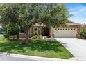 Charming home with a beautifully landscaped front yard, mature shade tree, and an inviting front porch at 9222 Sw 97Th Cir, Ocala, FL 34481