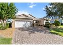 Inviting single-story home with a brick driveway, manicured lawn, and mature trees in a desirable location at 9926 Sw 95Th Loop, Ocala, FL 34481