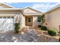 Welcoming front entrance with a brick walkway, beautiful landscaping, and a charming covered porch at 9926 Sw 95Th Loop, Ocala, FL 34481