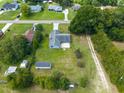 Aerial view of the home with a large backyard, shed, mature trees, and long driveway at 205 Ne 53Rd St, Ocala, FL 34479
