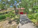 Home's front yard with lush greenery, long driveway, and colorful landscaping at 2676 Se 52Nd Ave, Ocala, FL 34480