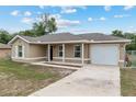 Single-story home featuring an attached garage, covered porch, and freshly painted exterior at 2690 Sw 154Th Ln, Ocala, FL 34473