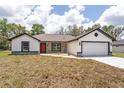 Charming single-story home featuring stone accents, a two-car garage, fresh grass, and a welcoming front door at 28 Water Track Dr, Ocala, FL 34472