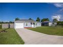 Bright home exterior with a long driveway and fresh green lawn under a blue sky at 3645 Sw 151St Ct, Ocala, FL 34481