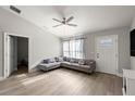 Modern living room with hardwood floors, stylish grey couch and a ceiling fan at 3645 Sw 151St Ct, Ocala, FL 34481