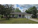 Charming single-story home featuring a cozy front porch, attached garage, and mature landscaping at 37 Oak Loop, Ocala, FL 34472