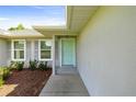 Close-up of a home's welcoming front door with gray shutters and tidy landscaping at 4325 Se 60Th St, Ocala, FL 34480