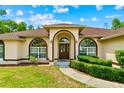 Inviting front entrance with arched windows, a pathway, and manicured landscaping enhancing its curb appeal at 4973 Sw 107Th Loop, Ocala, FL 34476