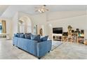 Bright living room featuring high ceilings, arched doorways, tile floors, and comfortable furnishings at 4973 Sw 107Th Loop, Ocala, FL 34476