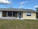 Single-story home features a screened porch, shutters, and an attached one-car garage on a cloudy day at 499 Water Rd, Ocala, FL 34472