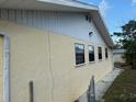 Exterior view featuring stucco siding with multiple windows and a paved walkway around the house at 499 Water Rd, Ocala, FL 34472