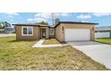 Exterior view of the modern home with attached garage and freshly landscaped front yard at 5 Dogwood Loop Ave, Ocala, FL 34472