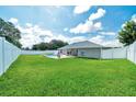Spacious backyard featuring a lush green lawn and a white fence for privacy and security at 5459 Sw 86Th St, Ocala, FL 34476