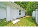 Side exterior view with a white door and freshly cut lawn and greenery at 6631 Se 11Th Loop, Ocala, FL 34472
