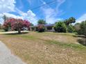 View of a single-story home with a spacious front yard and landscaping, offering curb appeal at 6814 Se 53Rd Pl, Ocala, FL 34472