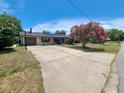Charming single-story home featuring a lovely front yard with mature landscaping and a long driveway at 6814 Se 53Rd Pl, Ocala, FL 34472