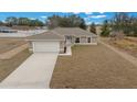 Aerial view of a single-story home showcasing a spacious lawn, attached garage, and inviting curb appeal at 7 Dogwood Trail Run, Ocala, FL 34472