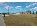 Single-story home with a long driveway, an attached two-car garage, and a well-maintained lawn at 7 Dogwood Trail Run, Ocala, FL 34472