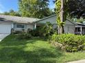 Landscaped front yard with lush greenery and a charming single-story home featuring a light brick facade at 8874 Sw 95Th St # B, Ocala, FL 34481