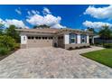 This lovely home features a two-car garage, stone driveway, manicured lawn, and elegant shutters at 9746 Sw 108Th Terrace Rd, Ocala, FL 34481
