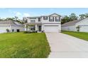 Charming two-story home featuring a well-manicured lawn and an attached two-car garage at 11205 Se 69Th Ter, Belleview, FL 34420