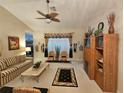 Cozy living room with a ceiling fan, carpet flooring, and lots of decor at 11298 Sw 73Rd Cir, Ocala, FL 34476
