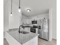 Modern kitchen showcasing white cabinets, granite countertops, and stainless steel appliances at 11506 Nw 20Th St, Ocala, FL 34482