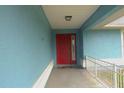 A quaint porch highlights the entry way, and features a red front door at 12524 Sw 109Th Pl, Dunnellon, FL 34432