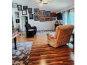 Living room with beautiful hardwood flooring, with plentiful artwork at 12524 Sw 109Th Pl, Dunnellon, FL 34432