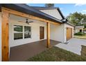 Inviting front porch with stained wood accents and a ceiling fan for added comfort and curb appeal at 13803 Se 44Th Ave, Summerfield, FL 34491