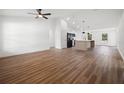 Open floor plan with wood-look floors connecting the living room and kitchen area with island at 13803 Se 44Th Ave, Summerfield, FL 34491