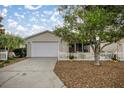 Inviting home with a well-manicured front yard, a picket fence, and an attached garage at 1405 Espinoza Ln, Lady Lake, FL 32159