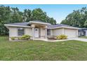 Charming single-story home featuring a well-manicured lawn and classic architectural details at 14650 Sw 33Rd Ln, Ocala, FL 34481
