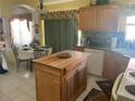 Spacious kitchen with an island, wooden cabinets, and tile backsplash at 1815 Puerto Bello Dr, The Villages, FL 32159