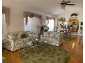 Comfortable living room with hardwood floors, glass coffee table and two sofas at 1815 Puerto Bello Dr, The Villages, FL 32159
