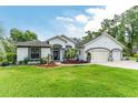 Charming one-story home with well-manicured lawn, inviting entryway, and convenient three-car garage at 19115 Sw 98Th Loop, Dunnellon, FL 34432