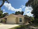 Side view of a single-story home with a well-maintained lawn and blue skies in a quiet neighborhood at 19480 Sw 100Th Loop, Dunnellon, FL 34432
