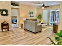 Inviting living room featuring wood floors, neutral furniture, and a view into an adjacent bedroom at 19480 Sw 100Th Loop, Dunnellon, FL 34432