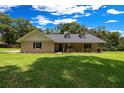 Inviting single-story home featuring a covered porch and lush green lawn at 26 Count Fleet Dr, Ocala, FL 34482