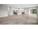 Spacious open floor plan with wood-look floors, a kitchen island, and modern appliances at 5 Larch Course Ter, Ocala, FL 34480